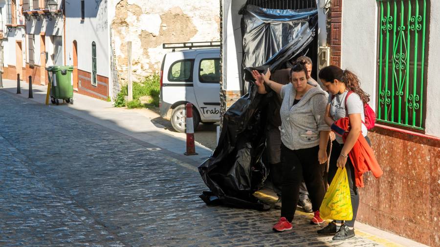 Tres personas salen del domicilio en Aznalcóllar (Sevilla), donde se cometió el crimen machista. FOTO: EFE