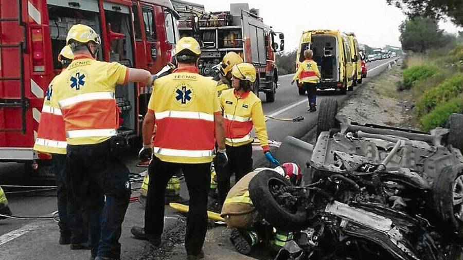 Els equips d’emergències treballant per treure del cotxe la persona ferida, en l’accident d’ahir a l’N-340 al terme municipal d’Alcanar. FOTO: Bombers de la Generalitat