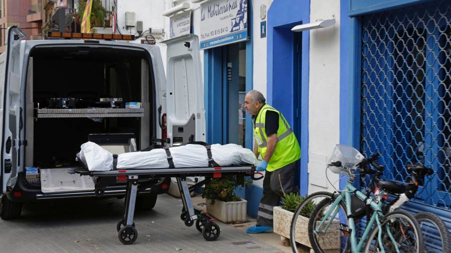 Un empleado de una funeraria saca el cadáver de un hombre que ha fallecido al ser tiroteado, supuestamente por una tercera persona, cuando se encontraba en un bar de Vilanova i la Geltrú. EFE
