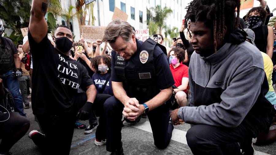 El comandante de la Policía de Los Ángeles Cory Palka se arrodilla con los manifestantes. FOTO: EFE