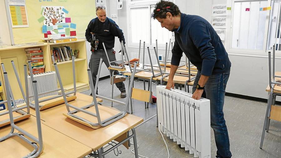 Miembros de la empresa Solcam instalaron ayer por la tarde los radiadores en las aulas prefabricadas de Els Ganxets.. FOTO: Alba Mariné