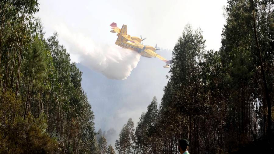 Un avión esparce agua sobre un incendio forestal hoy, en Pedrogao Grande (Portugal). Foto: EFE