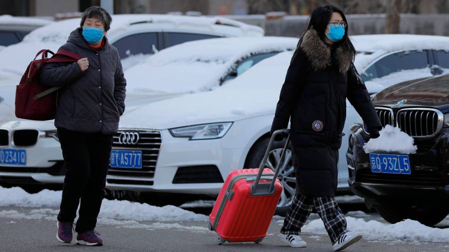 Dos mujeres chinas caminan con mascarilla. FOTO: EFE