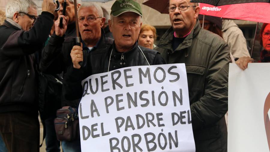 Pla mig d'un jubilat assistent a la manifestació de Barcelona convocada per 'UGT i CCOO per reclamar una millora de les pensions, amb un cartell que reclama la pensió del pare del Borbó, el 14 d'abril de 2018