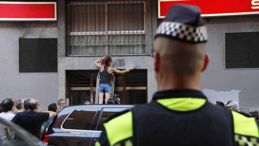 Imagen de una mujer retirando una de las placas de Tarragona. ACN