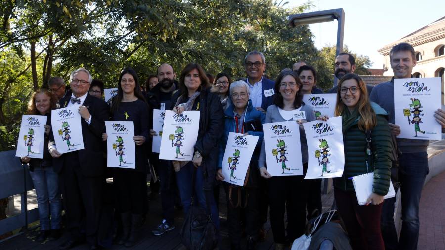 Representants d'entitats que formen part de Somescola mostren cartells de la plataforma en defensa de l'escola catalana a la biblioteca Tecla Sala de l'Hospitalet de Llobregat. FOTO: ACN
