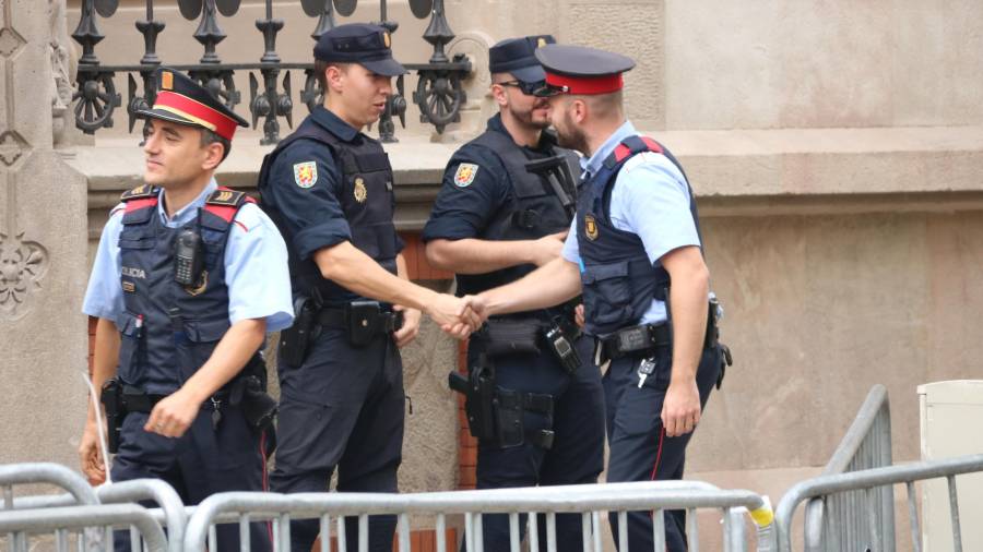 Agentes de los Mossos saludan agentes de la policía española, ante la delegación del Gobierno, antes de la primera reunión convocada por Pérez de los Cobos sobre el 1-O. FOTO: ACN