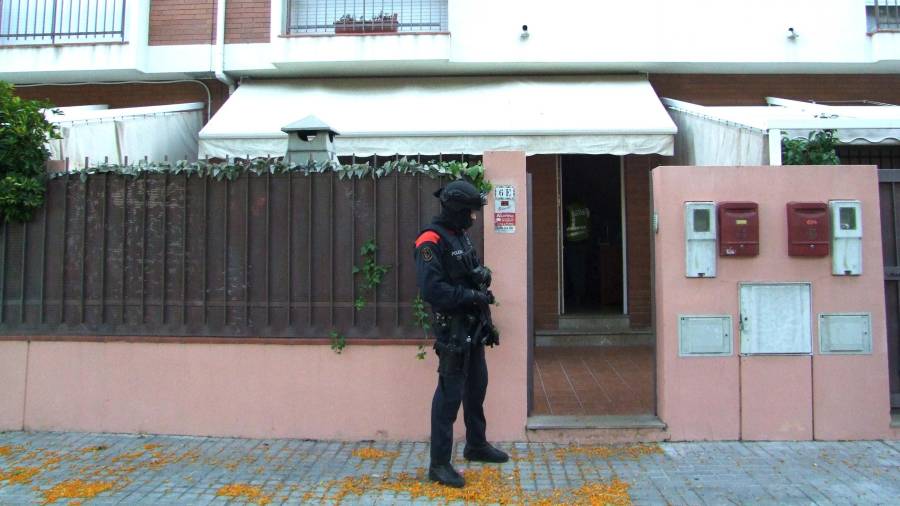 Un agent dels Mossos d'Esquadra vigila a les portes d'un dels domicilis escorcollats en l'operatiu policial per desarticular la banda criminal que cometia robatoris amb força. Foto: Mossos d'Esquadra