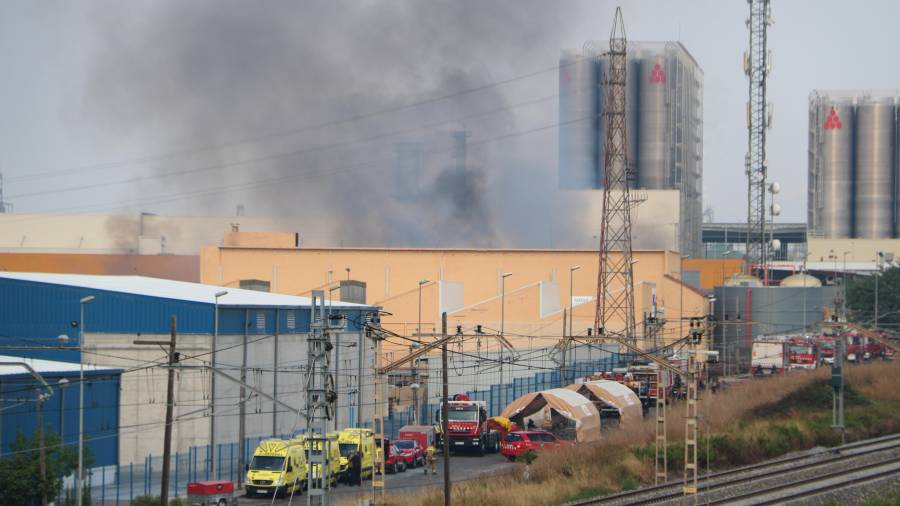 La nave industrial que arde en el polígono Entrevies de Tarragona y de las dotaciones de Bombers y del SEM. FOTO: ACN