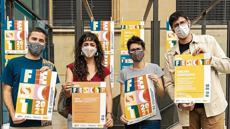 Algunos de los organizadores de Fira ira d’Economia Solidària con el cartel de las jornadas. FOTO: CEDIDA