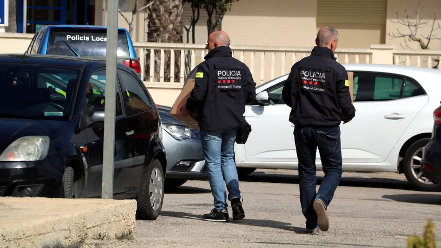 Dos agentes de Mossos llevando cajas de documentación que han requisado en Deltebre. ACN