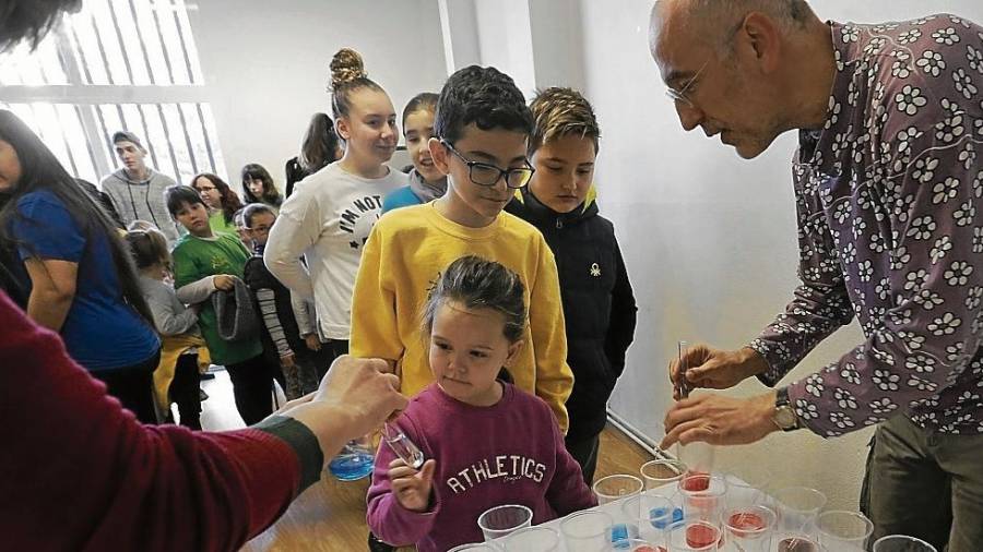 Los niños se disponen a recoger sus vasos de colores para preparar ‘mocos’, el primero de los experimentos. FOTO: Lluís Milián