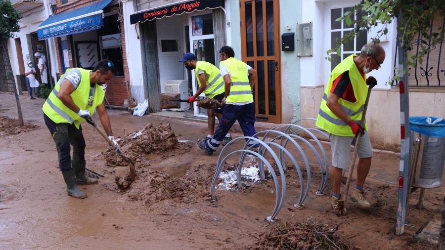 Imagen de algunos de los voluntarios que se han desplazado a Alcanar para ayudar a limpiar las calles tras las inundaciones. ACN