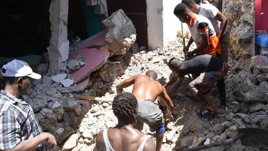Imagen de varias personas buscando supervivientes entre los edificios derrumbados por el terremoto en Haití. EFE