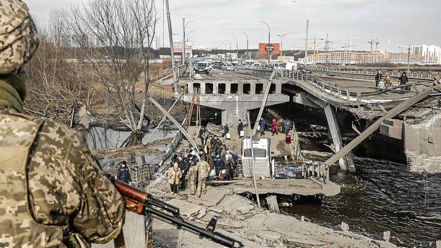 Civiles huyendo de Irpín, en la región de Kiev, por el puente destruido. Foto: EFE