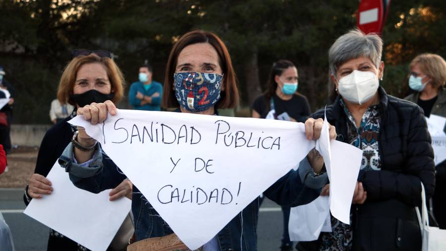 Imagen de una de las participantes en la protesta con un cartel en defensa de la sanidad pública. ACN