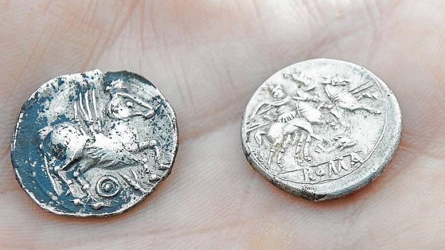 La moneda de l’esquerra a sota té dos símbols que en íber equivalen a «Kum». Foto: Joan Revillas