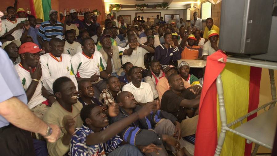 Parte de la comunidad senegalesa de Salou, siguiendo un partido de fútbol de su selección por televisión.