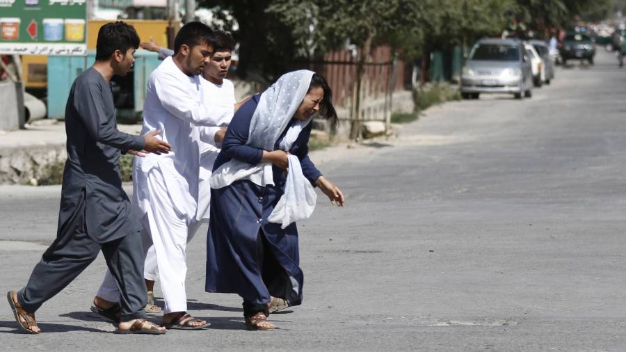 Civiles afganos huyen del lugar del atentado ocurrido en una mezquita de la minoría musulmana chií durante las oraciones de los viernes en Kabul