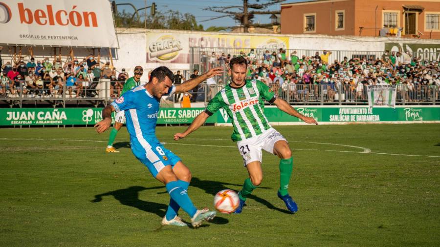 Pedro del Campo despeja el balón bajo la presión de un rival. Foto: Atlético Sanluqueño