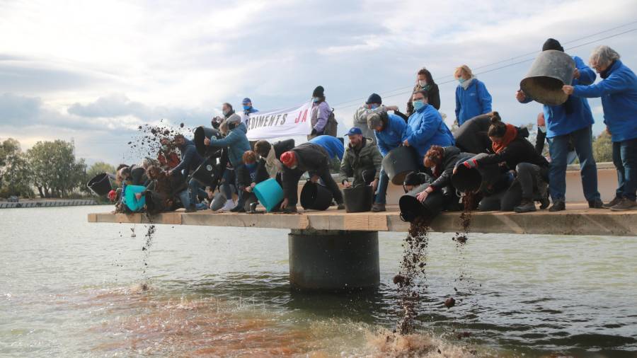 Abocament de sediments al riu per part de les entitats defensores del Delta en l'acció simbòlica celebrada al parc fluvial de Deltebre. ACN