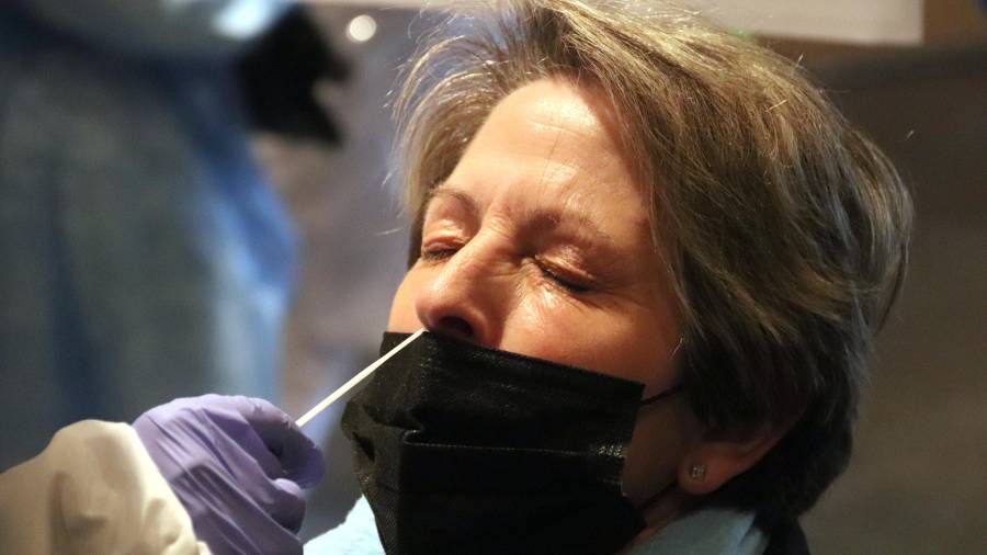 Una mujer con los ojos cerrados mientras le extraen una muestra para comprobar si es positiva de Covid. FOTO: ACN