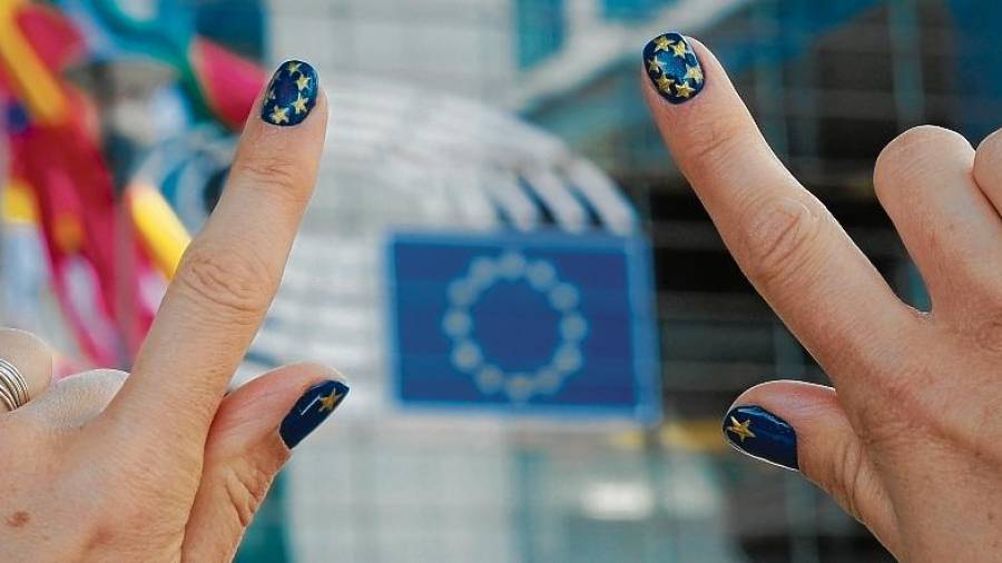 Una mujer muestra sus uñas pintadas con los colores de la bandera de la UE delante del Parlamento europeo en Bruselas. FOTO: EFE