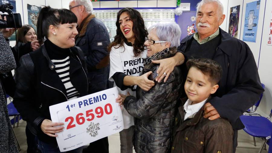oli sostiene el cartel del número mientras Reme abraza a su madre, Mari, en compañía de Francisco y de su nieto, Marc.