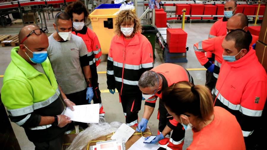 Trabajadores de la empresa Logaritme Servei Logístics revisan el cargamento con material enviado a Catalunya por Sanidad. FOTO: EFE