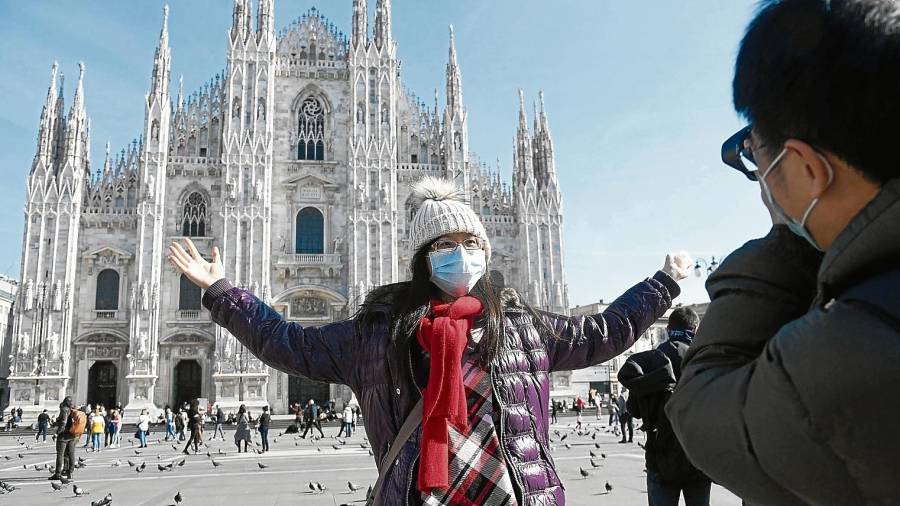 Una turista de Taiwán posa ante Il Duomo, la catedral de Milán. Foto: EFE