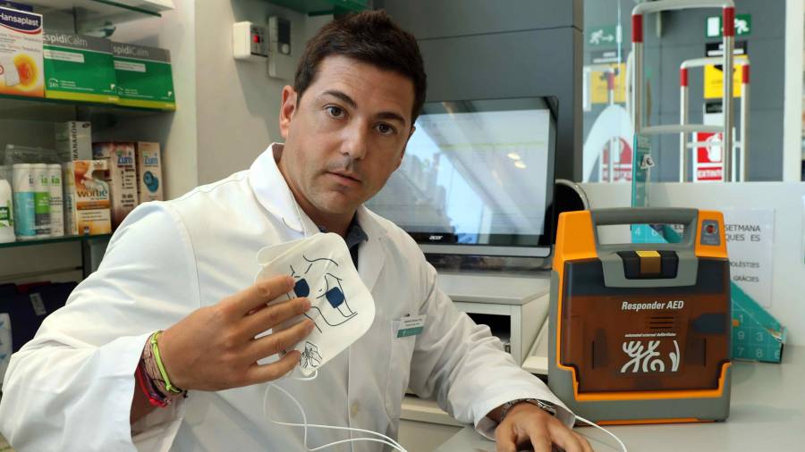 El titular de la Farmàcia Sarrià mostra el desfibril·lador amb què va salvar la vida a un ciutadà que havia patit un infart a la via pública. Foto: EFE