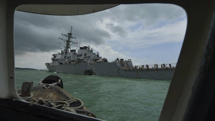 Vista de los daños en el casco del destructor de misiles guiados estadounidense USS John S McCain es remolcado al puerto de Singapur tras chocar con un barco mercante