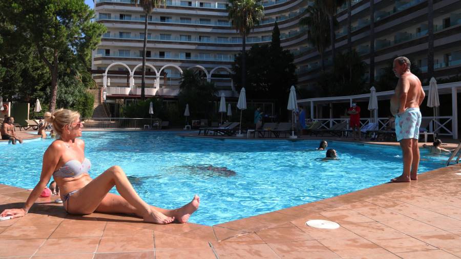 Plano abierto de dos turistas toman el sol en la piscina del Hotel Golden Port Salou. Foto: ACN