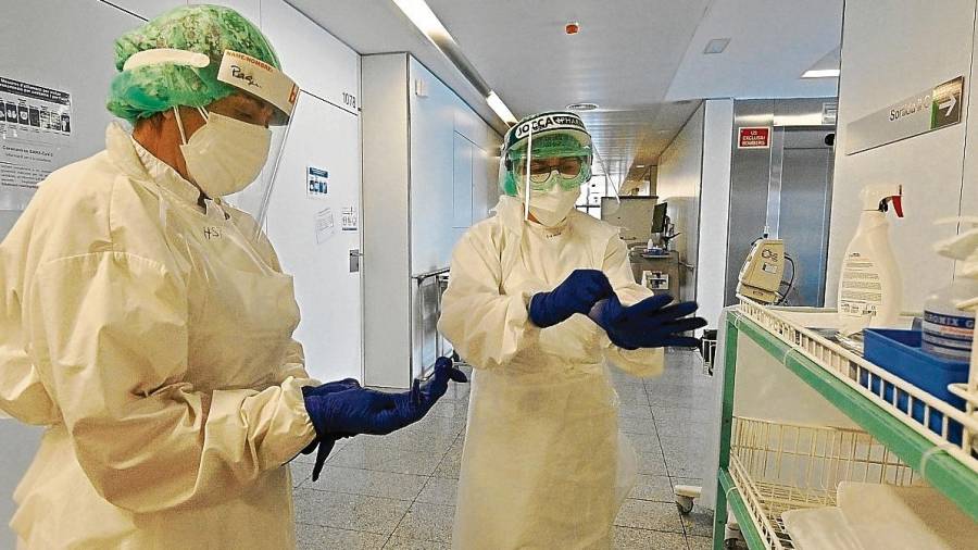 Dos sanitarios, protegiéndose con los EPI, en una planta de Covid del Hospital Sant Joan de Reus, durante la pandemia. FOTO: ALFREDO GONZÁLEZ