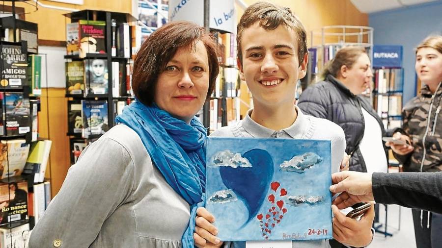 Pere posa con su madre Irina y el cuadro que pintó para conmemorar el Día Internacional del Autismo. FOTO: ALBA MARINÉ