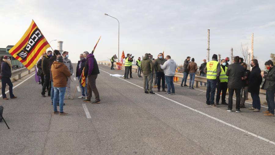 Plano abierto de un grupo de trabajadores de IQOXE concentrados en la entrada de la empresa durante la jornada de huelga. Foto: ACN