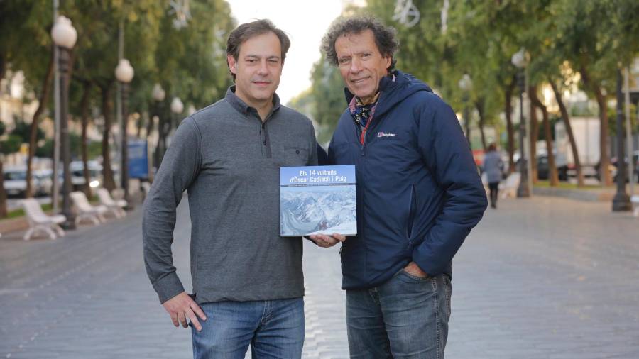 El periodista Francesc Joan junto con Óscar Cadiach con el libro que explica todas las expediciones del primer alpinista catalán en cubrir los 14 ochomiles del planeta. FOTO: lluís milián