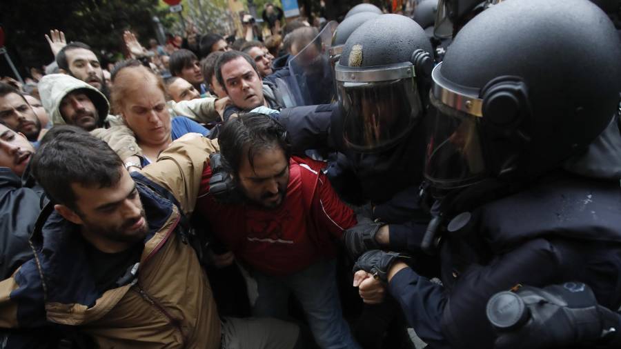 Imagen de los agentes antidisturbios de la Policía Nacional formando un cordón de seguridad frente al colegio Ramón Llull de Barcelona. FOTO: EFE