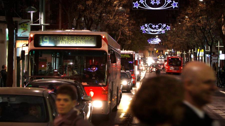 autobús metropolitano de Tarragona, de la línea 19 de la EMT, circulando por la noche y con luces de Navidad en la calle