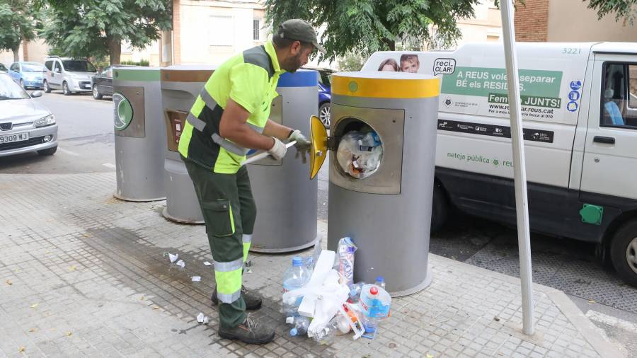 Un empleado del servicio de recogida de la basura se ve obligado a vaciar manualmente un contenedor atascado. FOTO: Alba Marine