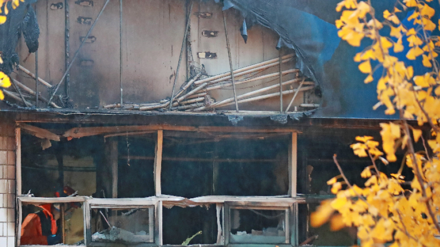 Un bombero camina a través de una casa de huéspedes destruida por un incendio. FOTO: EFE