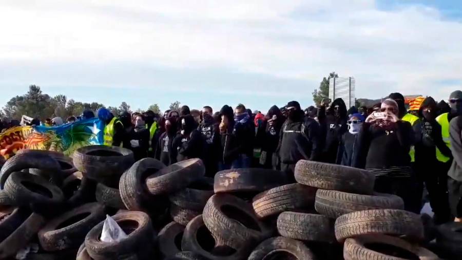 Encapuchados de los CDR del Camp de Tarragona ante una montaña de neumáticos a modo de barricada. Foto: Twitter.