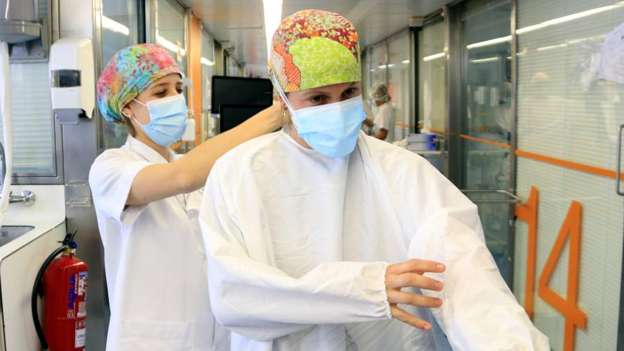 La enfermera Raquel González se equipa para entrar en la UCI del Hospital Clínic y atender a un paciente con Covid-19. FOTO: acn