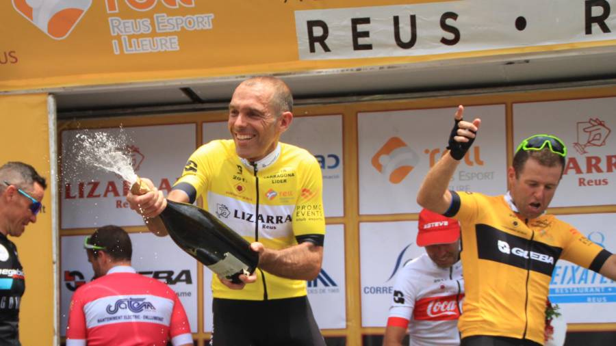 Carles Juncosa celebra su victoria con el maillot amarillo encima del podio de Reus. Foto: Raúl Rodríguez