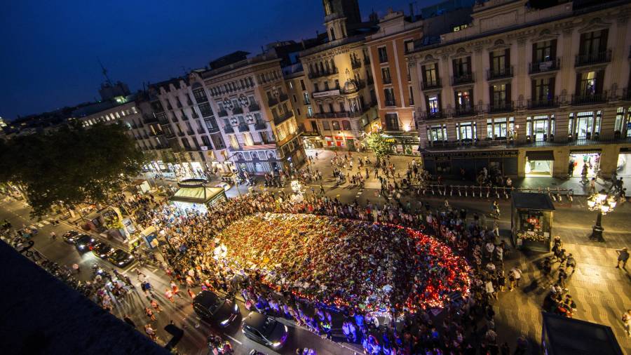 Centenares de personas cantan homenajeando a las víctimas en el mosaico de Joan Miró de las Ramblas, después de participar en la manifestación contra los atentados yihadistas en Cataluña. Foto: EFE.
