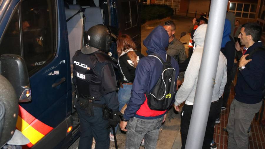 Plano general de la chica detenida subiendo a la furgoneta de la Policía Nacional, rodeada de agentes. Foto: ACN