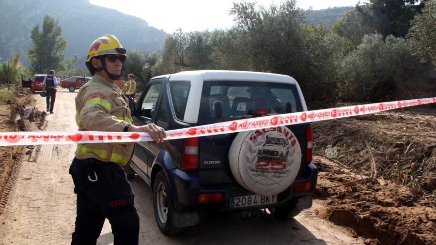 Un Bomber deja pasar el coche del médico forense en Vilaverd. FOTO: ACN