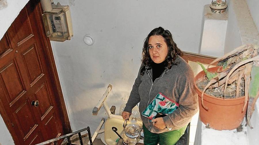 Elizabeth Alas en la escalera del piso con las garrafas con las que tiene que ir a buscar agua a la fuente. FOTO: Lluís Milián