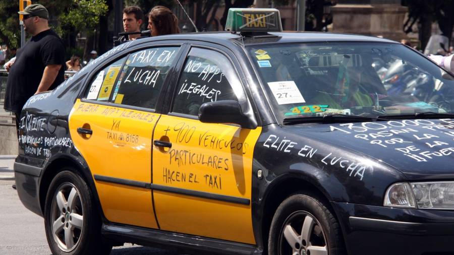 Un taxi de Barcelona con pintadas en contra de las plataformas de alquiler de vehículos con conductor. Foto: ACN