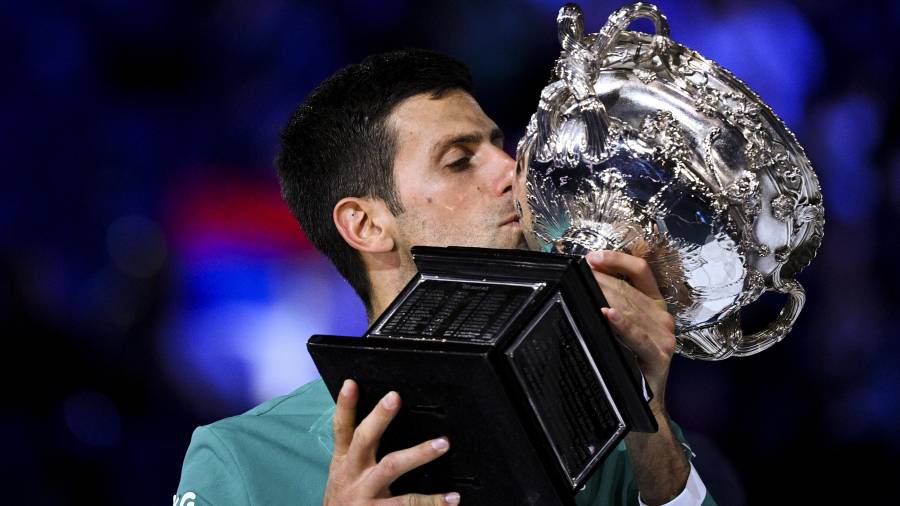 Nole Djokovic besa el trofeo del Abierto de Australia, el noveno que consigue en su carrera. FOTO: EFE
